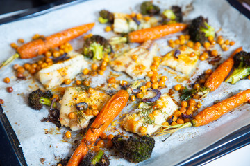 carrots, broccoli, chickpeas, fish fillets, onions and spices baked in the oven