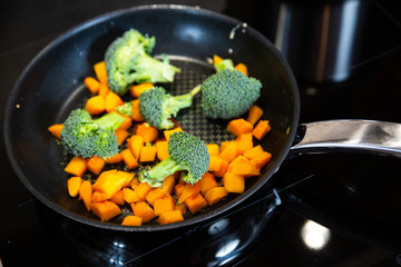 Baked broccoli and pumpkin to pan. Boiled broccoli and pumpkin on induction plate