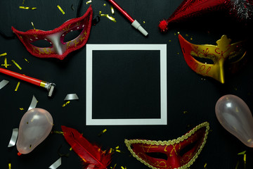 Table top view aerial image of beautiful colorful carnival festival background.Flat lay accessory object the several mask & decor confetti on modern black wooden at home office desk studio.copy space.