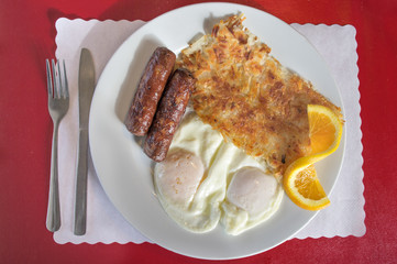 A typical America breakfst, eggs, hash browns, and sausage.