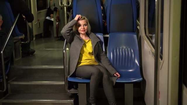 Blonde sitting in a subway car or funicular