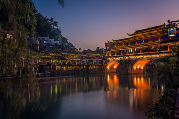 Illuminated historic arched bridge in Feng Huang