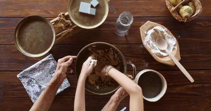 Top view preparing food. Cooking With Grandma. Beautiful Little Girl Learns How To Make Cookies.