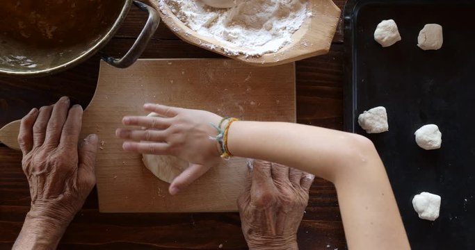 Top view preparing food. Cooking With Grandma. Beautiful Little Girl Learns How To Make Cookies.