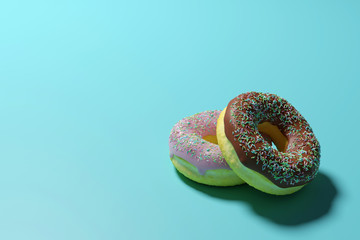The 3D Twin Donut with icing on the blue background, Chocolate and Strawberry Donut stack witn copy space for text,Glazed donut or doughnut with sprinkles 3d rendering