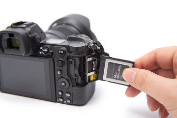 Man's hand holding XQD card on a white background.