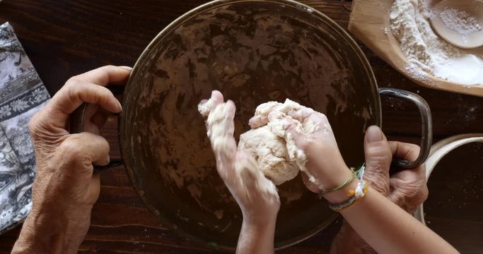 Top view preparing food. Cooking With Grandma. Beautiful Little Girl Learns How To Make Cookies.