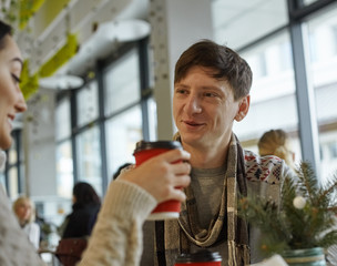 smiling young man talking to a woman in a cafe