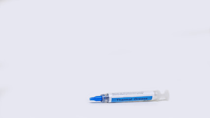 Generic tube of thermal paste used for heat dissipation between computer CPU, processor, GPU and cooler, isolated on white background.