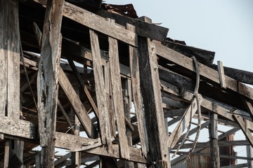 Ruins of an abandoned wooden house, rusty galvanized sheet roof