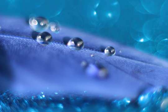 drops of water on the blue per, which lies on a shiny blue background