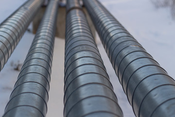 Pipes with hot and cold water. City communications. Metal pipes above the ground. Element of the water supply system.