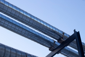 Pipes with hot and cold water. City communications. Metal pipes above the ground. Element of the water supply system.