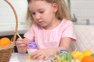 Obraz na płótnie Canvas Happy easter. Little girl painting Easter eggs. Happy family children preparing for Easter. Cute little child girl wearing bunny ears on Easter day.