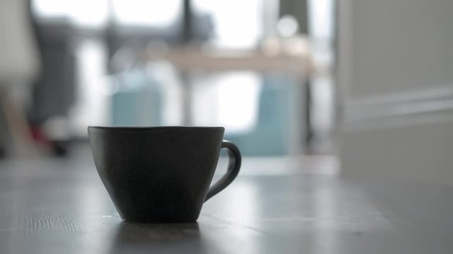 Cinemagraph - Close-up shot of a black cup with hot tea or coffee. Enjoy the morning