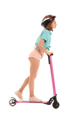 Teenage girl riding kick scooter on white background © Pixel-Shot