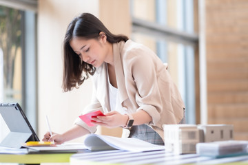 Architect or interior designer working with material sample board in showroom. Business of Real estate, home decoration .Creative people workplace.  young designer woman working happy and smile..