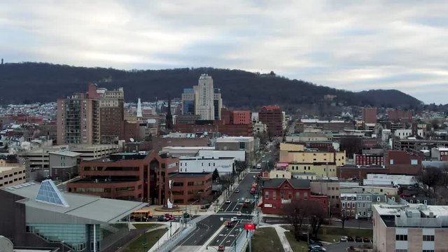 City of Reading, PA, USA, slow rising aerial reveals downtown urban city center with residential housing on outskirts under morning winter