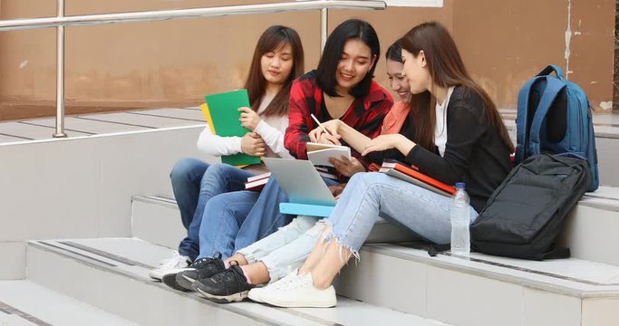 A group of Asian girl students doing their report by notebook computer  in free time in school.