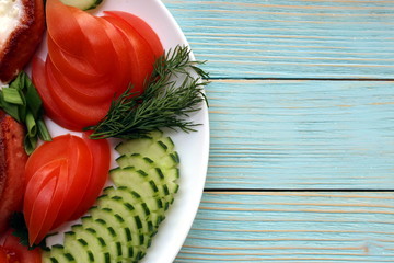 Red ripe beautifully sliced tomato lies on a dish as a decoration
