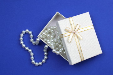 In a white box lies pearl beads