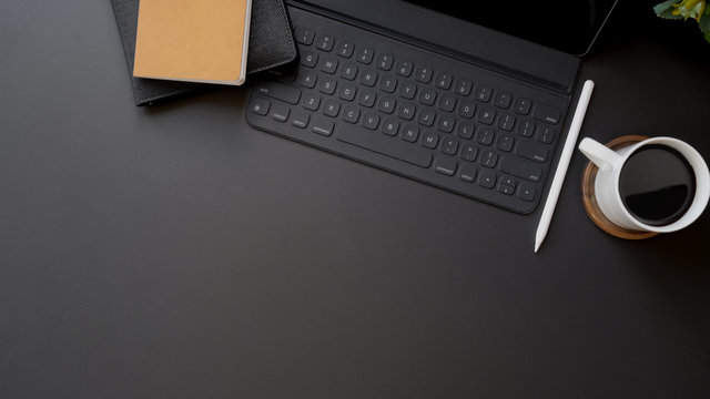 Top view of dark modern workplace with copy space on black table background