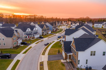 Aerial sunset panorama of luxury real estate development single family house neighborhood curving street with dramatic sky in Maryland USA © tamas