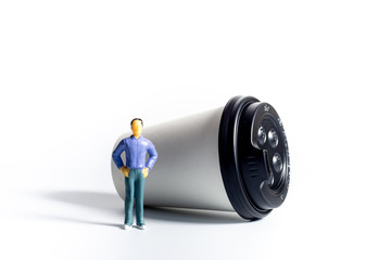 Miniature People and Coffee to-go Cup on white background. Cafe menu concept. Shallow depth of field.