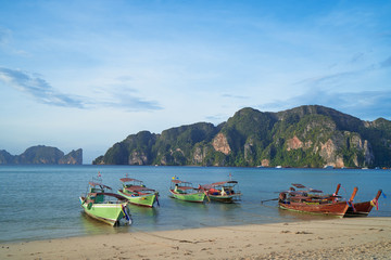 Fototapeta na wymiar Travel by Thailand. Landscape with traditional longtail fishing and tourists boat on the sea beach.