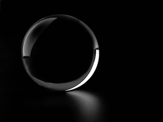 Crystal glass ball sphere transparent isolated on dark background.