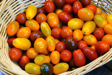 Basket of colorful organic heirloom tomatoes at the farmers market