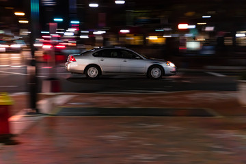 Fototapeta premium Silver Car Speeding Through Intersection