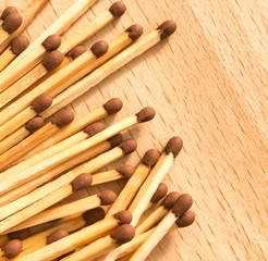 many wooden matches lie on a wooden background. flammable matches on a wooden table.