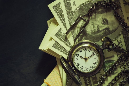 Vintage pocket watch on dollar banknote. At 8 o&rsquo;clock in morning. Top view and copy space. Concept of time and business to succeed in vintage style.