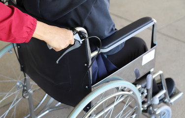 Obraz premium Closeup of woman assistant's hand taking care a patient in wheelchair.
