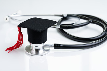 Graduation hat on doctor stethoscope, white background using as medical school, health care...