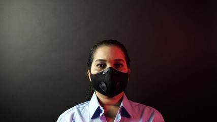 Close up of self protected African American female face in white shirt and urban protective black mask. Prevention and protection infection by deadly coronavirus 2019-nCoV, pandemic in China concept.