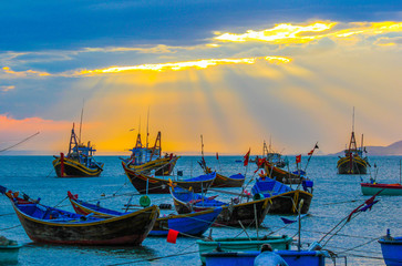 Fototapeta na wymiar Anchorage of colorful fishing boats at sunset background Vietnamese