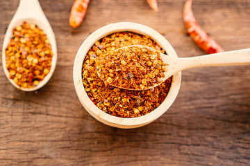 chili pepper powder in bowl on wooden table