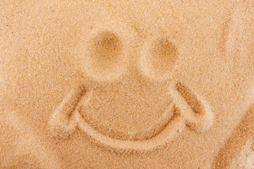 Fototapeta na wymiar Symbol of a smile painted on sand