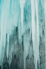 Russia. Lake Baikal. March. Ice grotto. Beautiful blue icicles of unusual shape