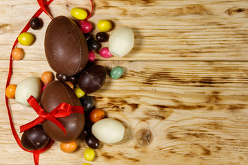 Easter composition with chocolate eggs on wooden background