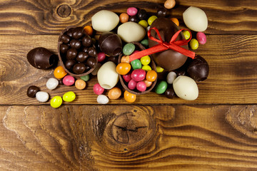 Easter composition with chocolate eggs on wooden background