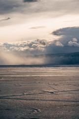 Baikal, Russia, March. Yellow light from the sun covers the ice on the lake. Far away on a mountain background