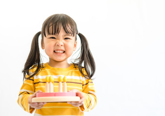 Cute adorable little asian toddler girl celebrating birthday while holding strawberry cake wooden...