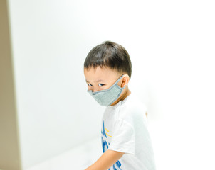 Coronavirus and Air pollution pm2.5 concept.Little chinese wuhan boy wearing mask for protect pm2.5 in Airport terminal.Toddler boy play in airport.Wuhan coronavirus and epidemic virus symptoms.