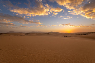 Obraz na płótnie Canvas Sand dunes in the National Park of Dunas de Corralejo during a beautiful sunset, Canary Islands - Fuerteventura