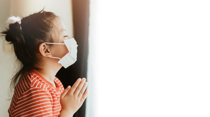 Coronavirus and Air pollution pm2.5 concept.Little chinese girl wearing mask for protect pm2.5 and pray for stop corona virus outbreak.Wuhan coronavirus and epidemic virus symptoms.Copy space.