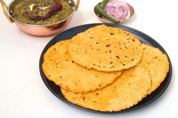 Sarson ka saag and Makke di roti. mustard leaves curry. its a popular punjabi winter dish made using corn meal & mustard leaves. served with onions and green chili in copper vessels. with copy space.