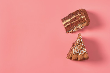 Two pieces of chocolate cake lies on pink table. Copy space. Top view